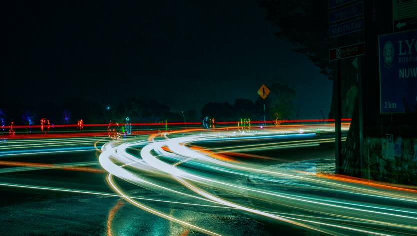 Una imagen que muestra las luces de los vehículos en movimiento durante la noche en una carretera.