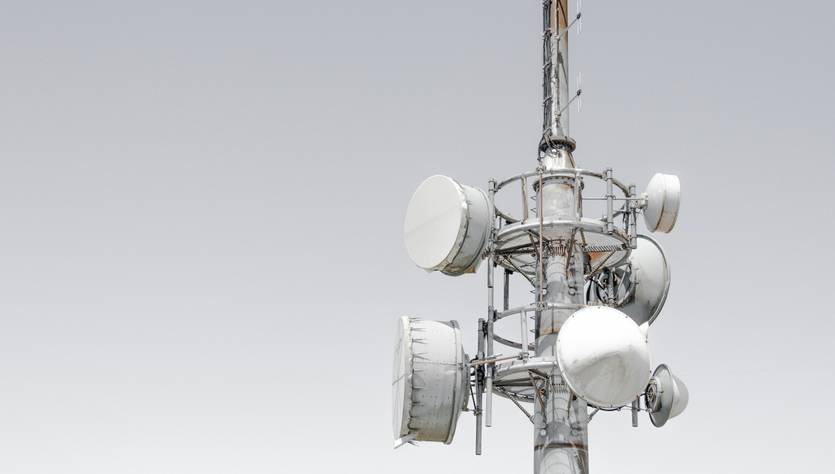 Una torre de telecomunicaciones con varios paneles de antena en su estructura.