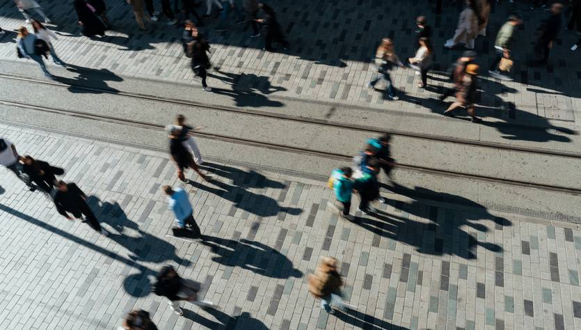 Una vista aérea de una multitud de personas caminando por una acera sobre un pavimento de adoquines.