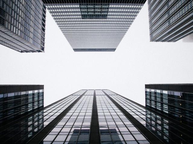 Vista desde abajo de edificios modernos que se elevan hacia el cielo.