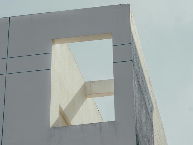La imagen muestra una esquina de un edificio moderno con un gran marco vacío en la parte superior.