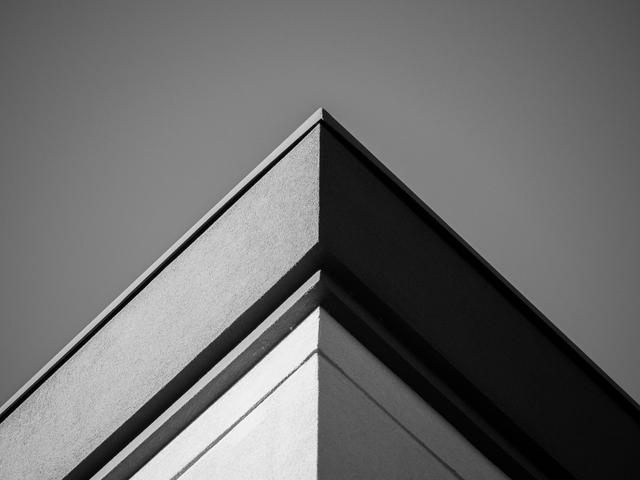 Una esquina arquitectónica en blanco y negro que muestra líneas limpias y angulares.