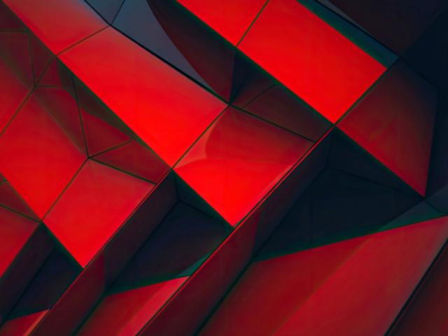 La imagen muestra una superficie con formas geométricas en tonos rojos, creando un efecto visual dinámico.