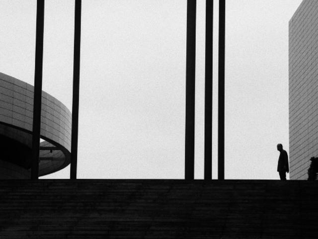 Una figura solitaria se destaca en un paisaje urbano en blanco y negro.