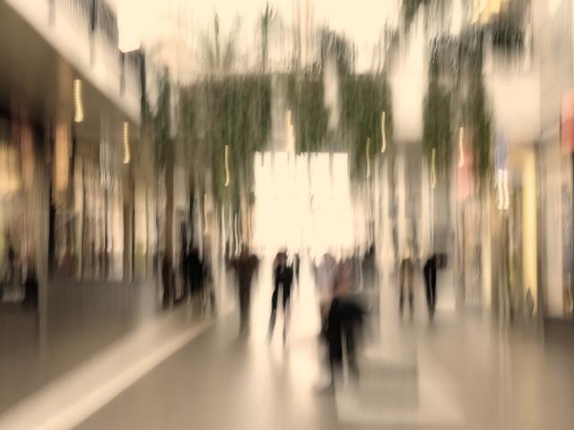 Una imagen desenfocada de un centro comercial con personas caminando.