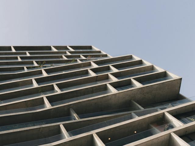 Una vista en ángulo de un edificio moderno con una fachada de concreto.