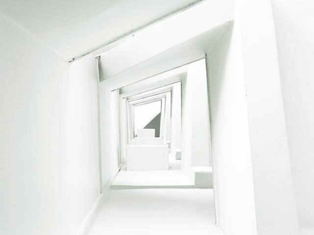 Una serie de pasillos blancos que crean un efecto visual de profundidad y repetición.