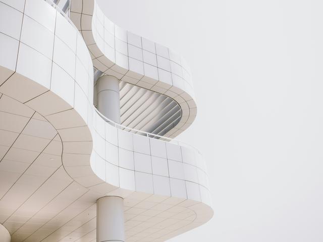 Una estructura arquitectónica moderna de color blanco con líneas curvas y detalles elegantes.