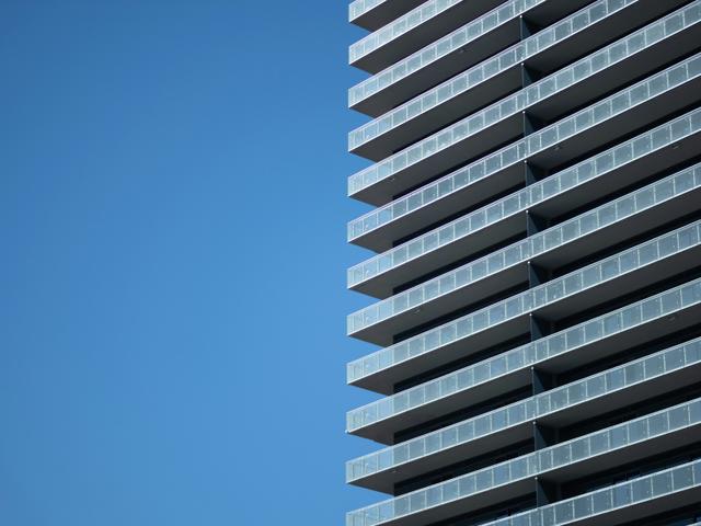 Una imagen de un edificio moderno con balcones en un día despejado.