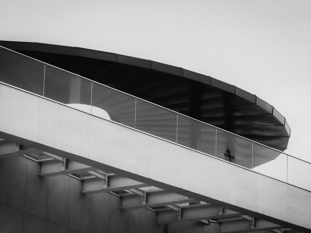 La imagen muestra una estructura arquitectónica moderna con un diseño curvilíneo en un entorno minimalista.