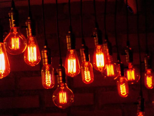 Una serie de bombillas de luz cálida colgadas, emitiendo un brillo anaranjado intenso.