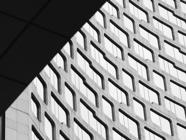 Una imagen en blanco y negro que muestra la estructura de un edificio moderno con un diseño arquitectónico curvilíneo.
