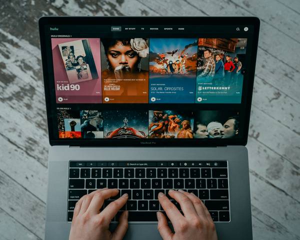 Una persona está usando una laptop con una interfaz de streaming de películas y series.